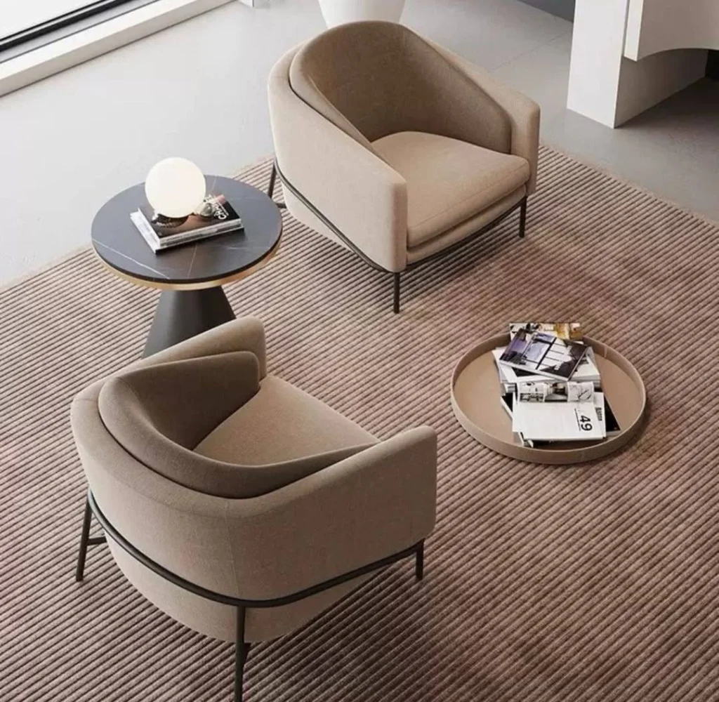 Pair of curved taupe barrel accent chairs with black legs and round side table