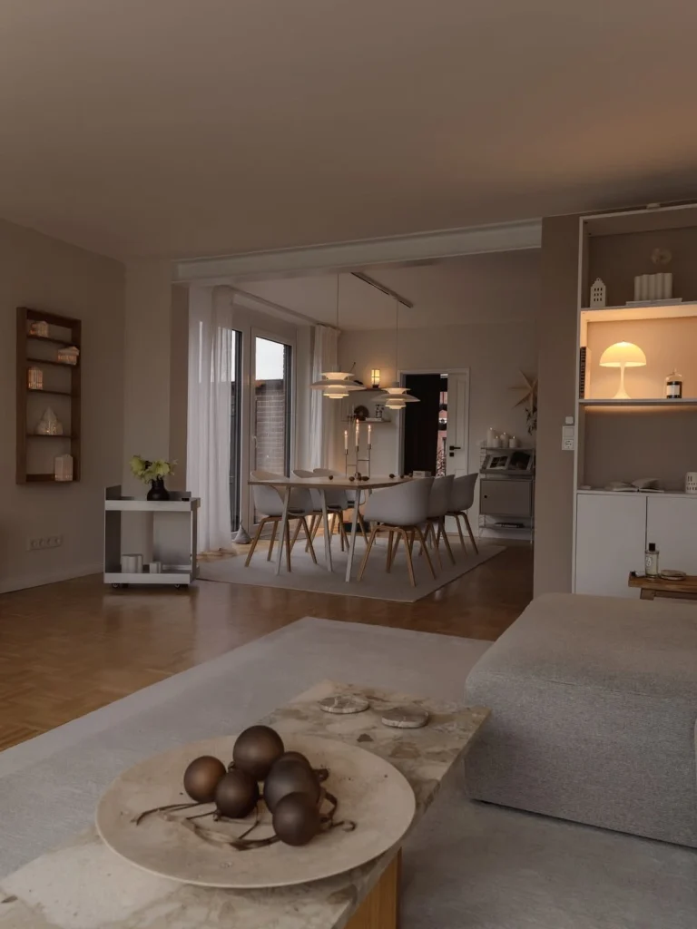 Cosy Scandinavian open-plan living and dining room with warm candlelight and built-in shelving