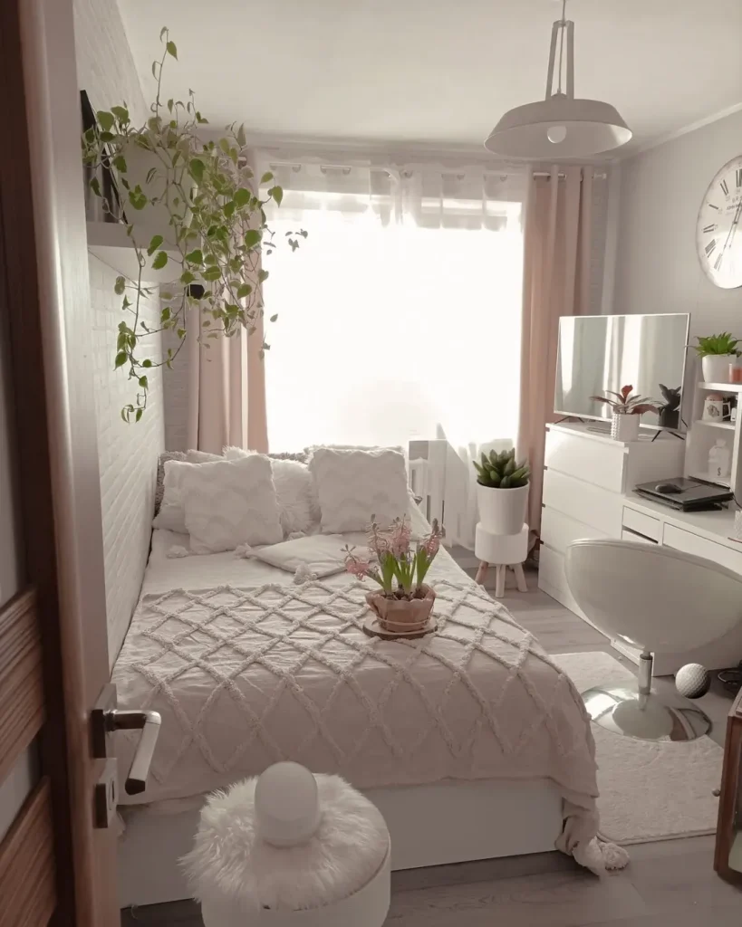 Bright white tiny bedroom with trailing pothos plant, sheer pink curtains