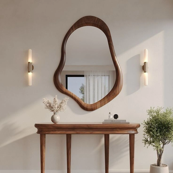 Dark walnut organic frame mirror above console table with lamp and dried florals