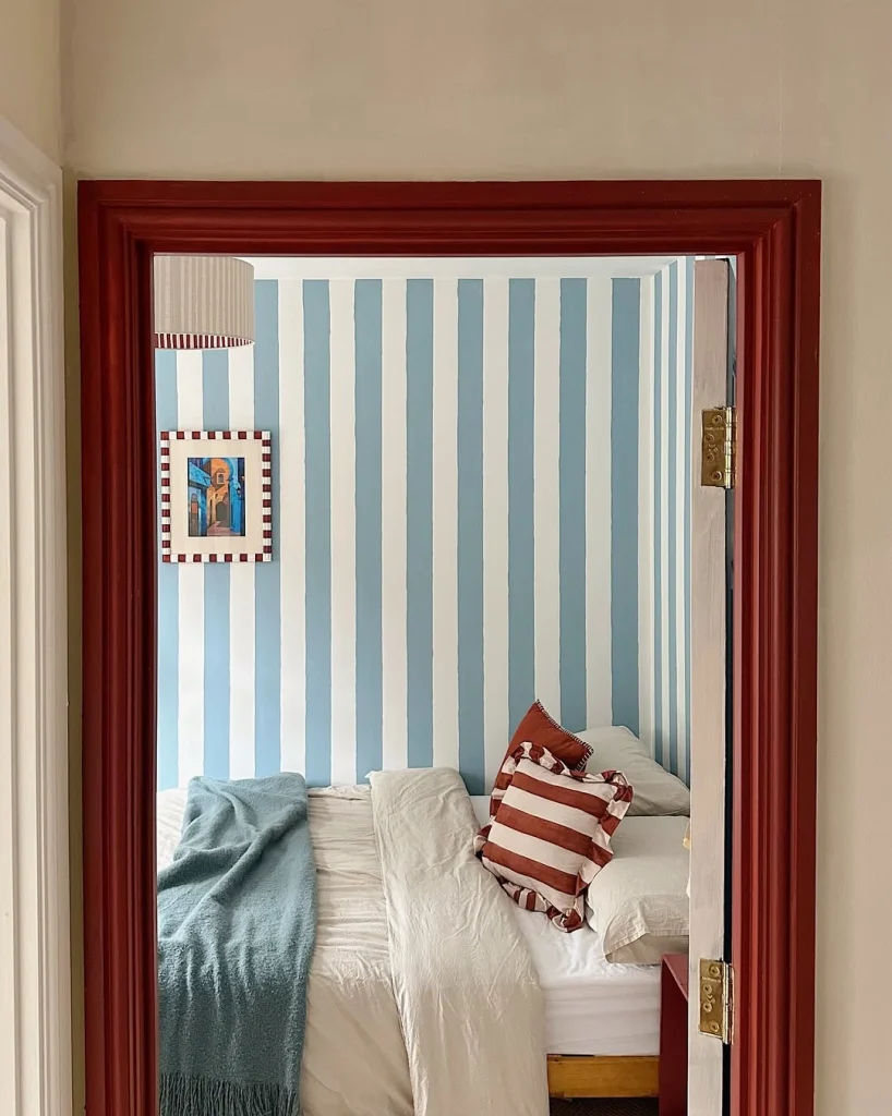 Deep red painted door frame leading into a bedroom